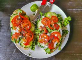 smörgås bröd smörgås baguette grönsaker gurkor tomater vitlök lök sallad. foto