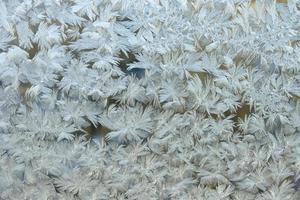 fruset vinter fönster med glänsande is frost mönster textur. christmas wonder symbol, abstrakt bakgrund. extrem nordlig låg temperatur, naturlig issnö på frostigt glas, svalt vinterväder utomhus. foto