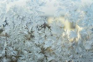 fruset vinter fönster med glänsande is frost mönster textur. christmas wonder symbol, abstrakt bakgrund. extrem nordlig låg temperatur, naturlig issnö på frostigt glas, svalt vinterväder utomhus. foto