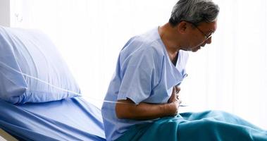 manlig patient hasing bröst smärta på sjukbädd på sjukhus rum. foto