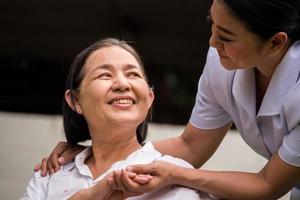skön sjuksköterska tar vård av kvinna patient på de sjukhus parkera foto