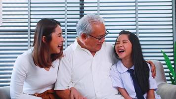 Lycklig familj med farfar, mor och liten dotter utgifterna tid tillsammans i levande rum. foto
