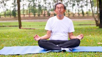 asiatisk man håller på med yoga på de parkera. foto