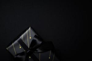 topp se av svart gåva låda med svart band isolerat på svart bakgrund. foto
