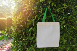 vit tote canvas tyg eco bag tyg shoppingsäck på gröna blad natur bakgrund foto