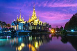 skön tempel thailand dramatisk färgrik himmel skymning solnedgång skugga på vatten reflexion med ljus foto