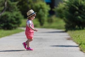 liten flicka springer i sommarparken foto