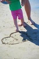 mamma och bebis på stranden har kul foto