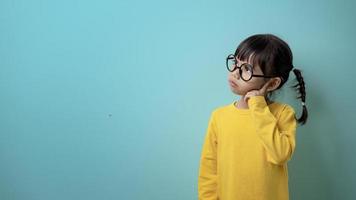 rolig barn flicka bär glasögon på en färgad bakgrund foto