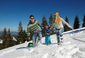 familj har roligt på färsk snö på vinter- foto