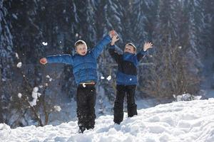 barn spelar med färsk snö foto