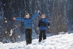 barn spelar med färsk snö foto