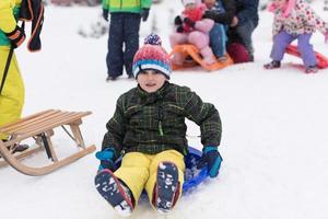 liten pojke har roligt på vinter- dag foto