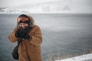 fotograf på vinter- i stormig väder bär värma päls jacka foto