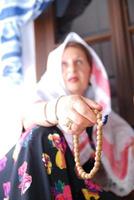 kvinna med bön pärlor foto