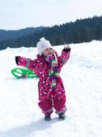 liten bebis flicka ha roligt på färsk snö foto