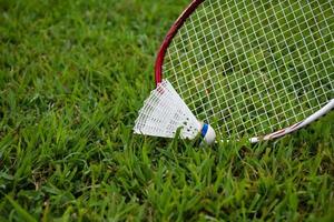 badminton utomhus utrustning badmintonbollar och badminton racketar, på gräsmatta, mjuk och selektiv fokus på fjäderbollar, utomhus- badminton spelar begrepp foto