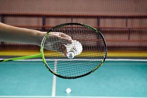 inomhus- badminton spelar förbi tjänande badmintonbollar racketar. utomhus- badminton spelar begrepp. foto