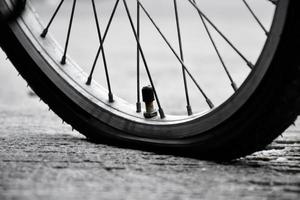 bak- hjul av cykel som är platt och parkerad på de trottoar bredvid de väg. foto