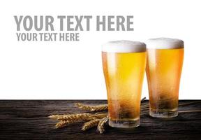 kall öl med vete på trä- tabell. glasögon av ljus öl på isolera vit bakgrund med kopia Plats. foto