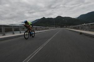 triathlonatlet som cyklar på morgonträning foto