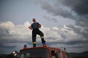 brandman ut av plikt på topp av lastbil foto