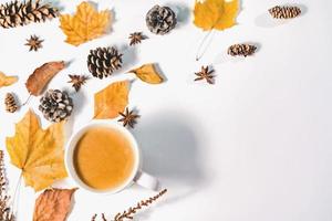 höstens sammansättning. kopp kaffe, höstlöv, kanelstänger och anistjärnor på klarblå pastellbakgrund. platt låg, ovanifrån kopia utrymme. foto