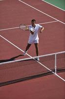 ung man spela tennis utomhus foto