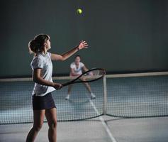 ung flickor spelar tennis spel inomhus- foto