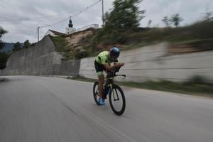 triathlonatlet som cyklar på morgonträning foto