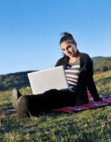 ung tonåring flicka arbete på bärbar dator utomhus foto