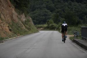 triathlonatlet som cyklar i svart foto