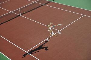 ung kvinna spela tennis utomhus foto