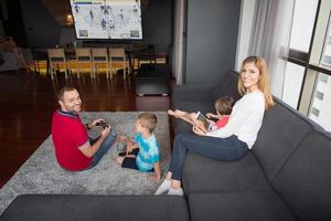 Lycklig familj spelar en hockey video spel foto