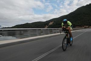 triathlonatlet som cyklar på morgonträning foto