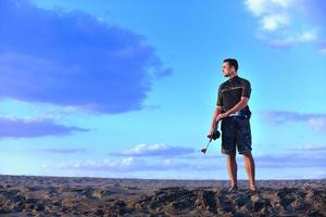 porträtt av en ung kitsurf man på strand på solnedgång foto