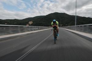 triathlonatlet som cyklar på morgonträning foto