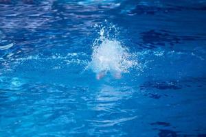 simmar övning på inomhus simbassäng foto