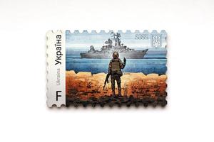 ternopil, ukraina - september 2, 2022 känd ukrainska poststämpel med ryska örlogsfartyg och ukrainska soldat som trä- souvenir på vit bakgrund foto