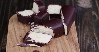 flytta de bitar av ostmassa ost i choklad glasyr med socker foto