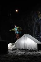 freestyle snowboardåkare hoppa i luft på natt foto