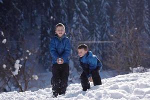 barn spelar med färsk snö foto