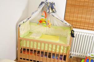 bebis säng med färgrik leksaker inomhus- foto