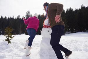 Lycklig familj byggnad snögubbe foto