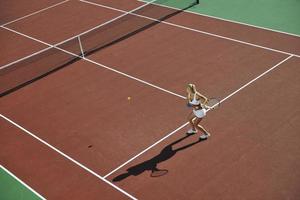 ung kvinna spela tennis foto