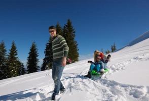 familj har roligt på färsk snö på vinter- semester foto