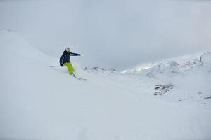 skidåkning på nysnö på vintersäsongen på vacker solig dag foto