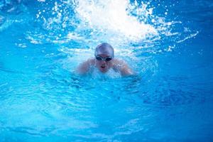 simmar övning på inomhus simbassäng foto