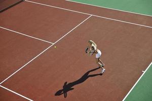 ung kvinna spela tennis utomhus foto