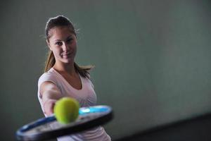 ett ung kvinna spela tennis foto
